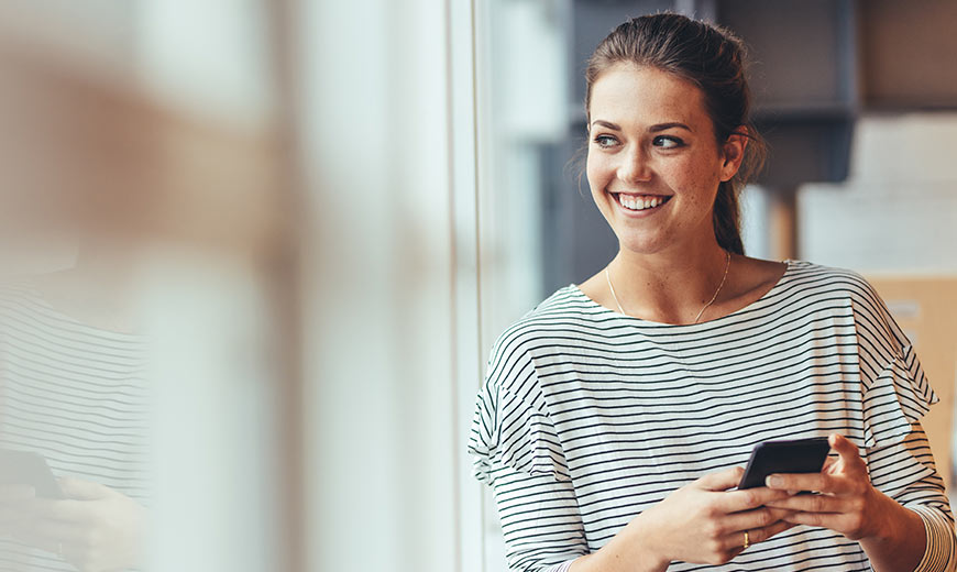 Woman smiling and holding the phone.