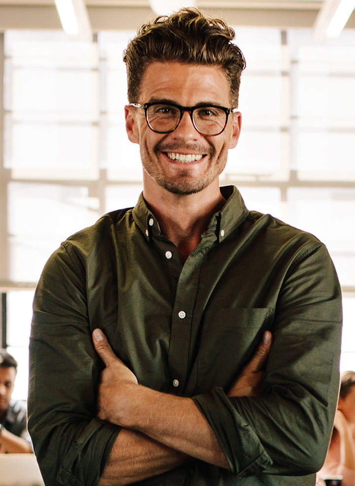 Man with glasses smiling and posing.