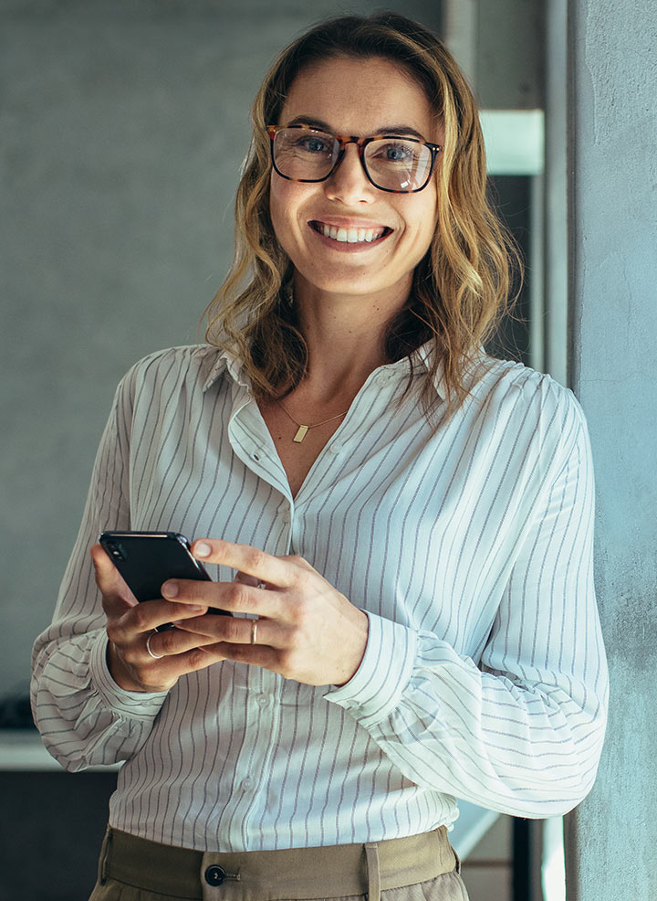 Woman with glasses smiling and posing.