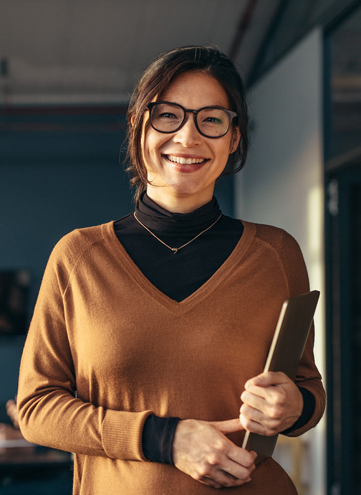 Woman with glasses smiling and posing.