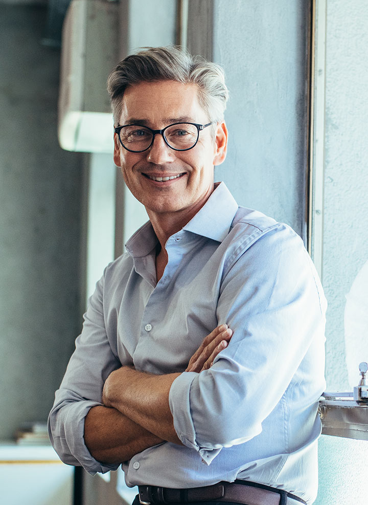 Man with glasses smiling and posing.