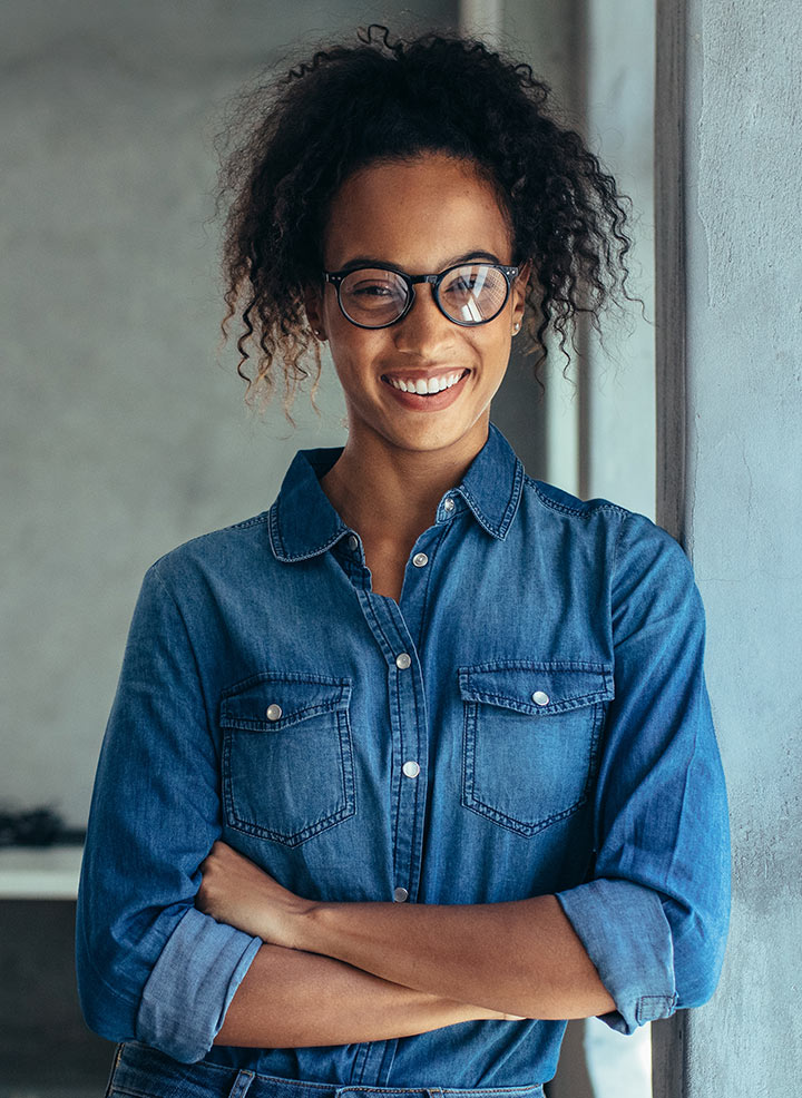 Woman with glasses smiling and posing.
